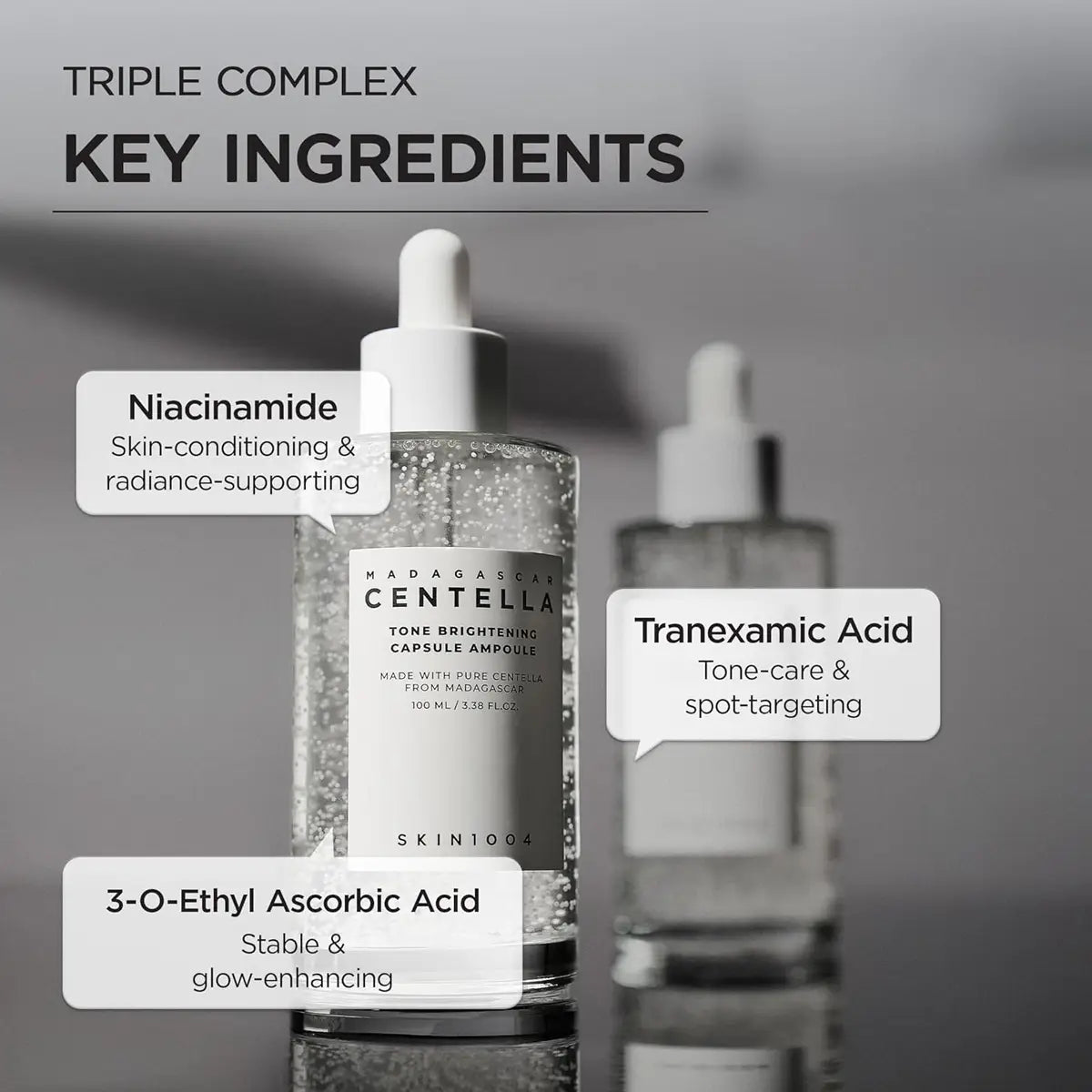 Skincare bottle with key ingredients labeled on a gray background