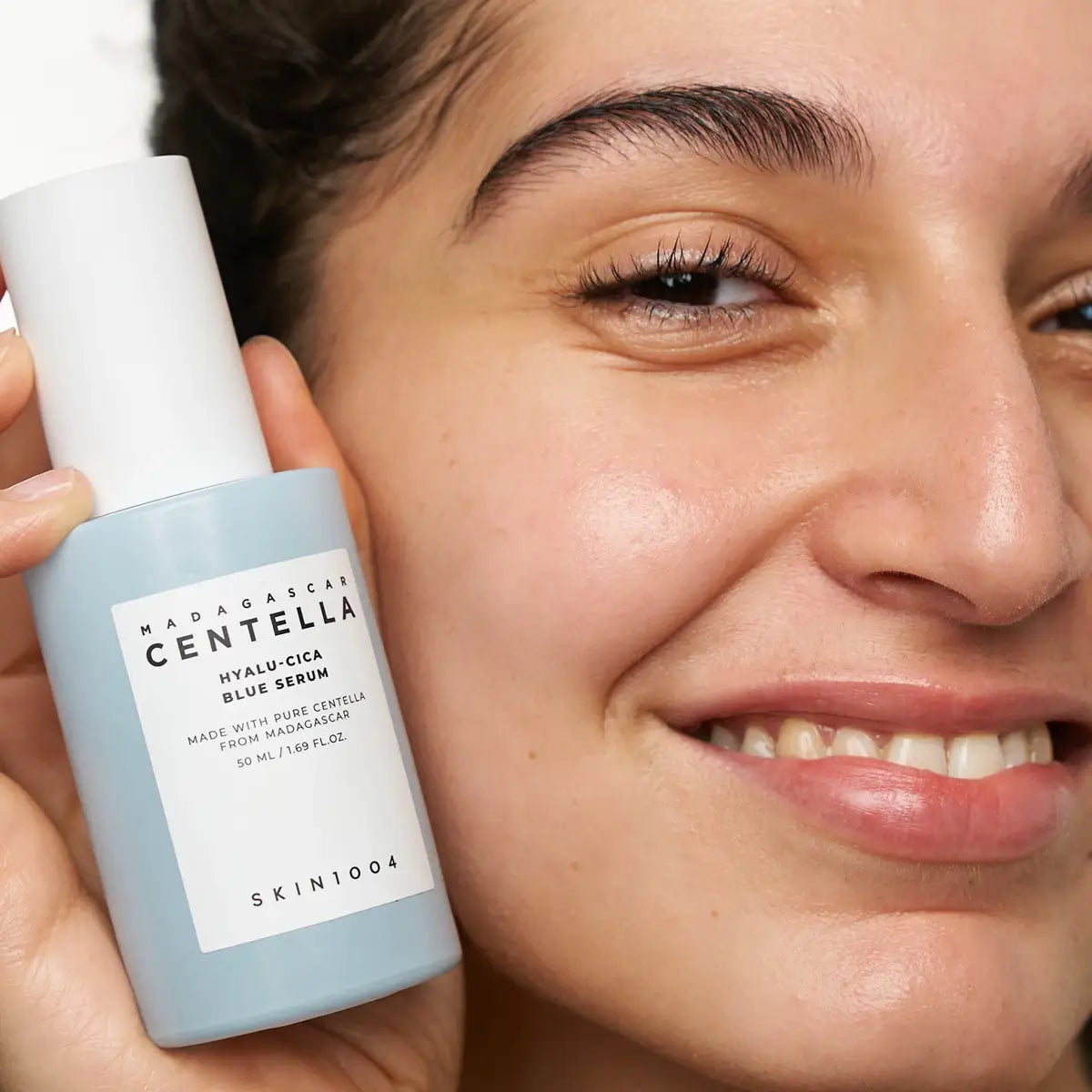 Lady holding Skin1004 Madagascar Centella Hyalu-Cica Blue Serum bottle