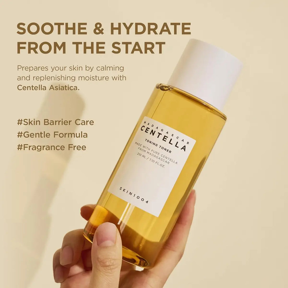 Hand holding a bottle of skincare product with text about skin care benefits on a beige background