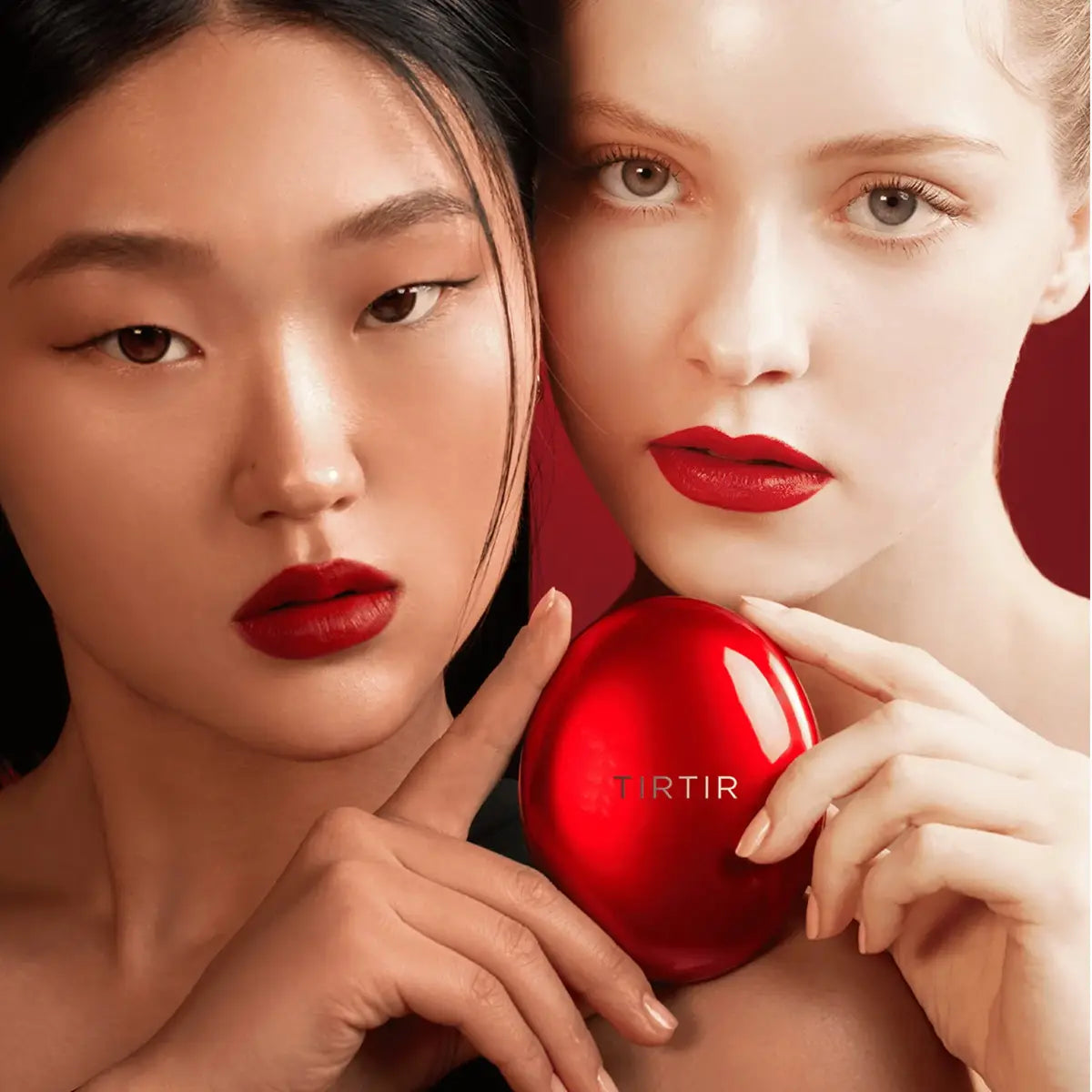 Two women holding a red TIRTIR product against a dark background