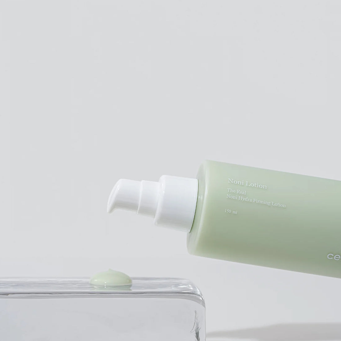 Green lotion bottle with white cap on a light gray background