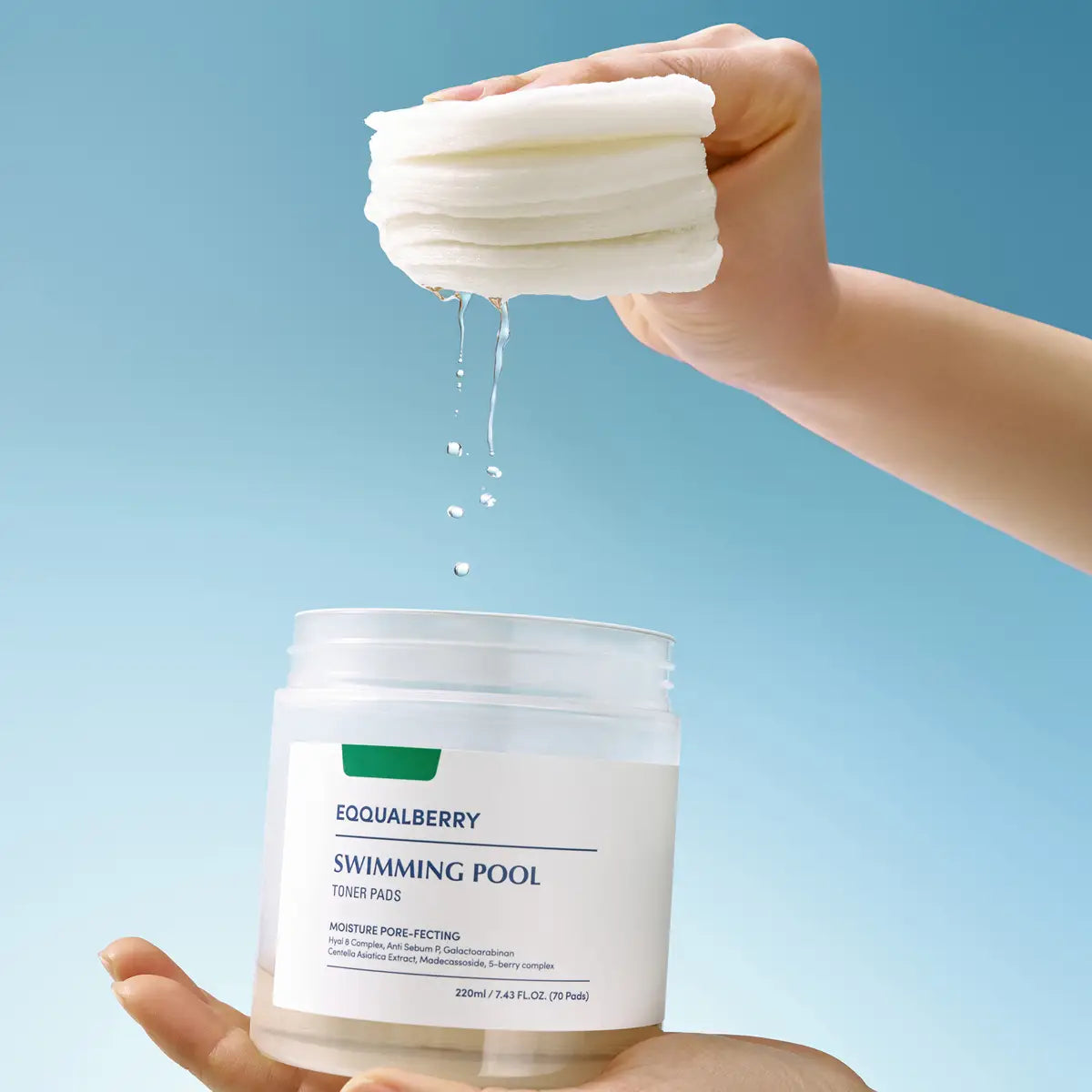 Hand holding a stack of white pads above a container labeled 'EQQUALBERRY Swimming Pool Toner Pads' against a blue background.