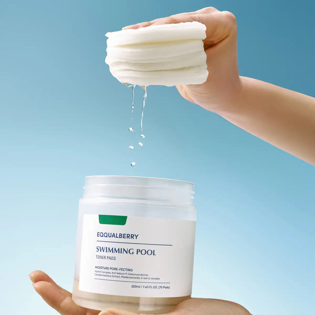Hand holding a stack of white pads above a container labeled 'EQQUALBERRY Swimming Pool Toner Pads' against a blue background.
