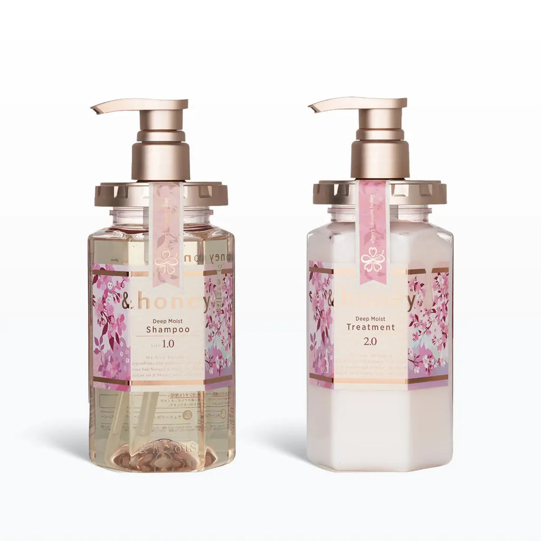 Two bottles of shampoo and conditioner with cherry blossom design on a white background