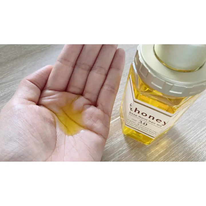 &Honey Deep Moist Hair Oil 100mL in hand showing its nourishing texture and lightweight formula for hair care.
