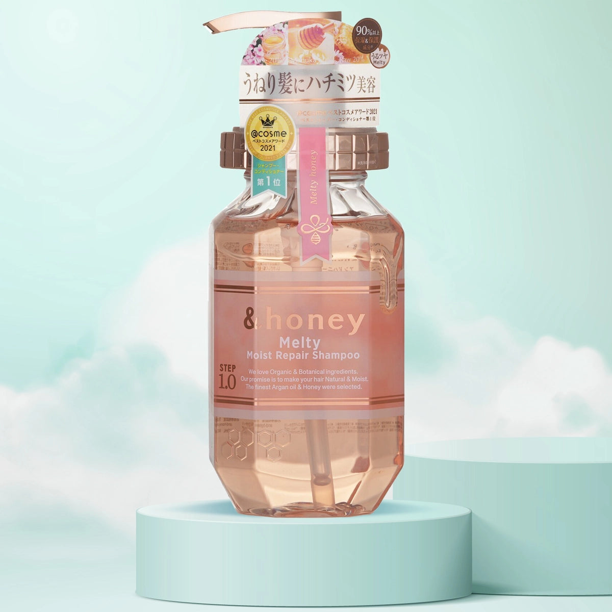 A plastic bottle of &Honey Melty Moist Repair Shampoo with a pink label, displayed against a sky and cloud background.