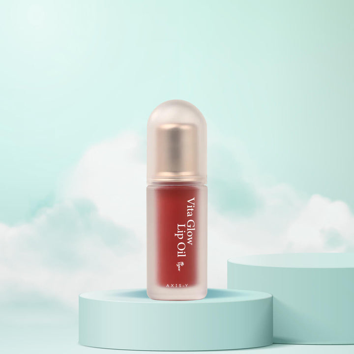 Lip oil with 'Axis-Y Vita Glow' branding on a light blue background