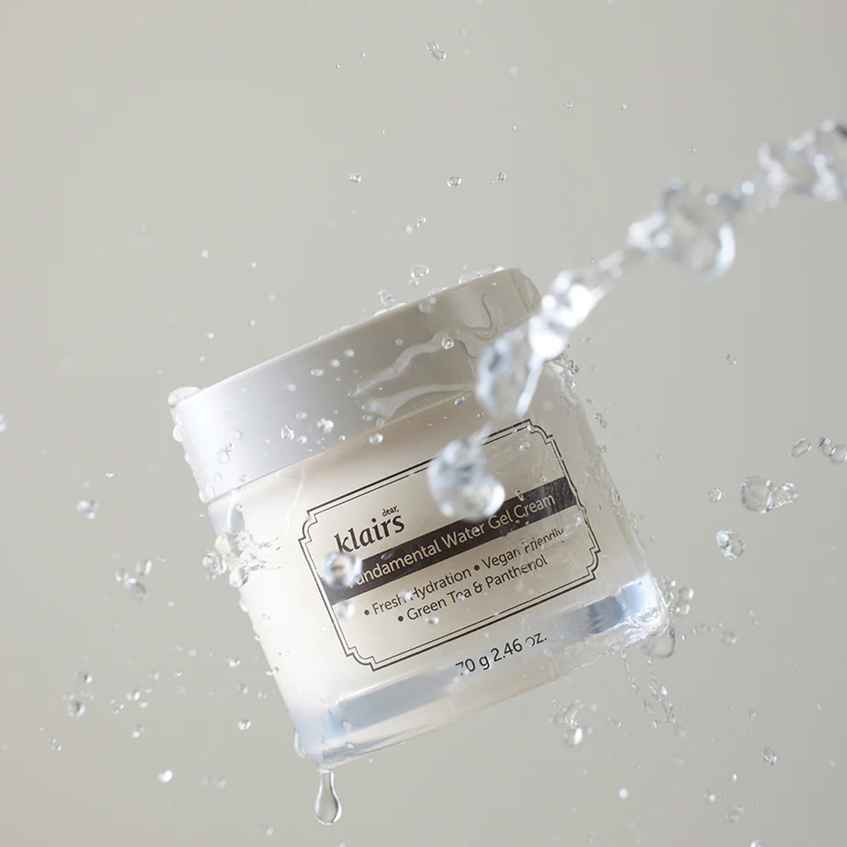 Klairs jar of cream with water droplets on a light gray background