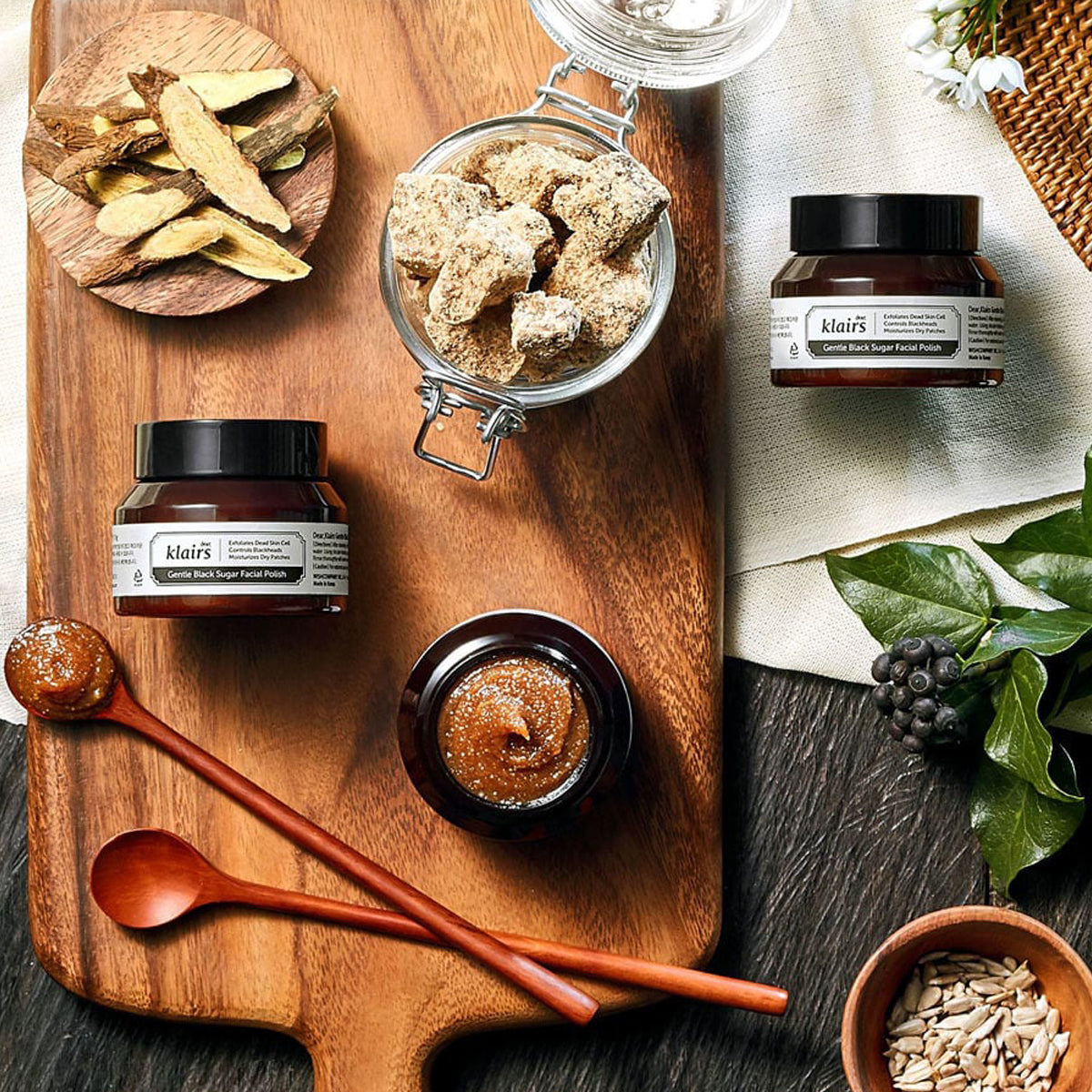 dear Klairs jar with brown paste on a wooden board with ingredients and spoons.