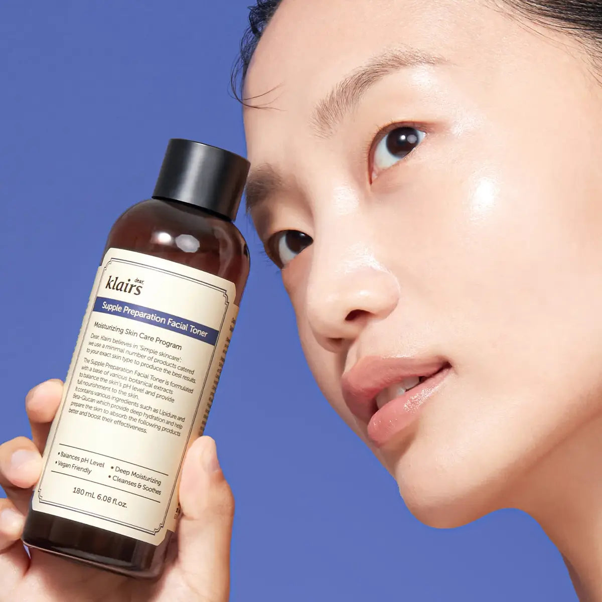 Person holding a bottle of Klairs Supple Preparation Facial Toner against a blue background