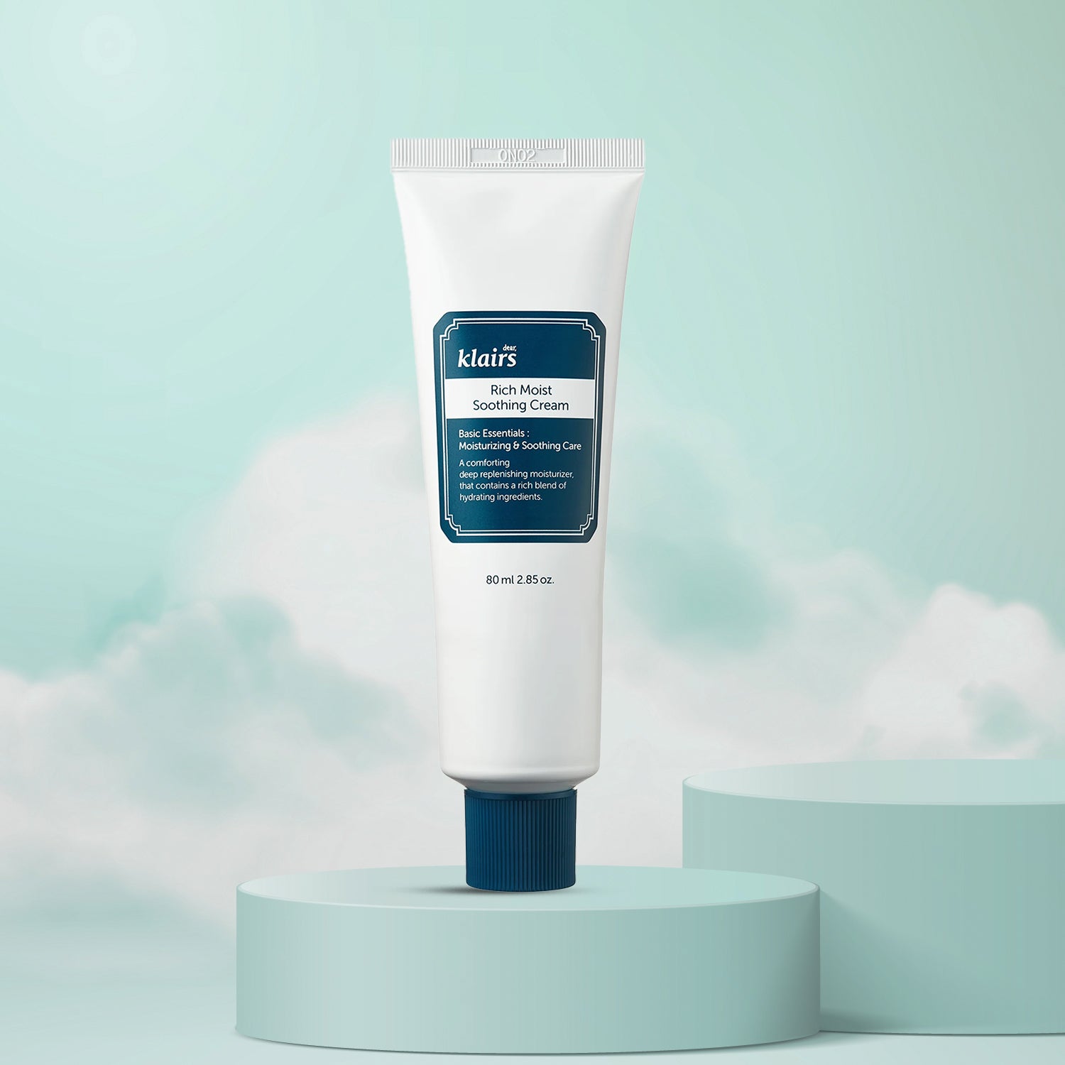 A tube of Dear KLAIRS Rich Moist Soothing Cream placed on a pedestal against an backdrop with clouds, indicating a soothing and moisturizing skin care product.