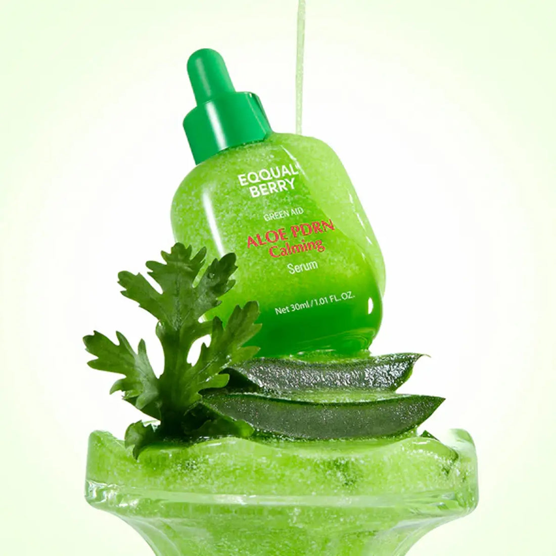 Green aloe vera serum bottle with leaves on a light green background