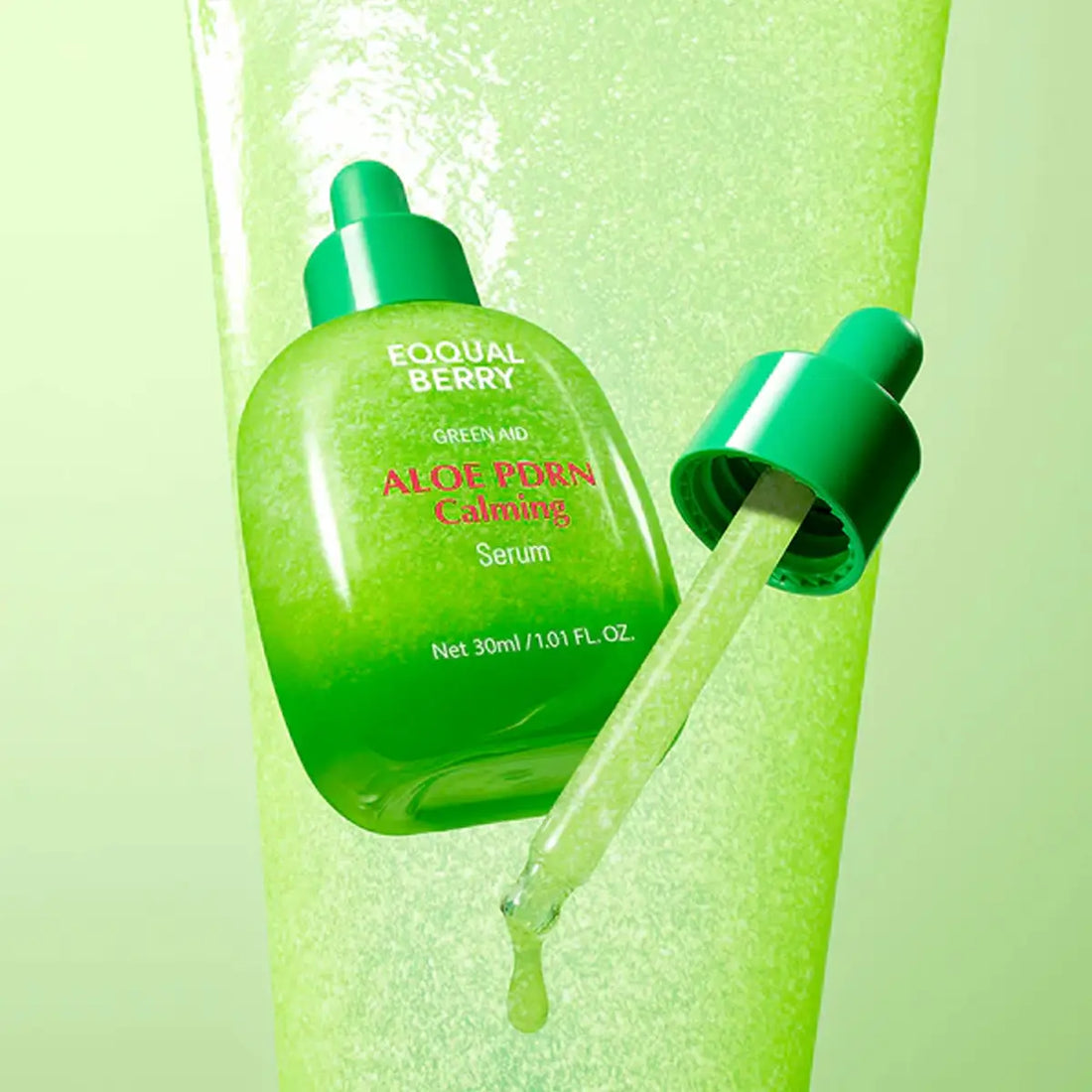 Green aloe vera serum bottle with dropper on a green background