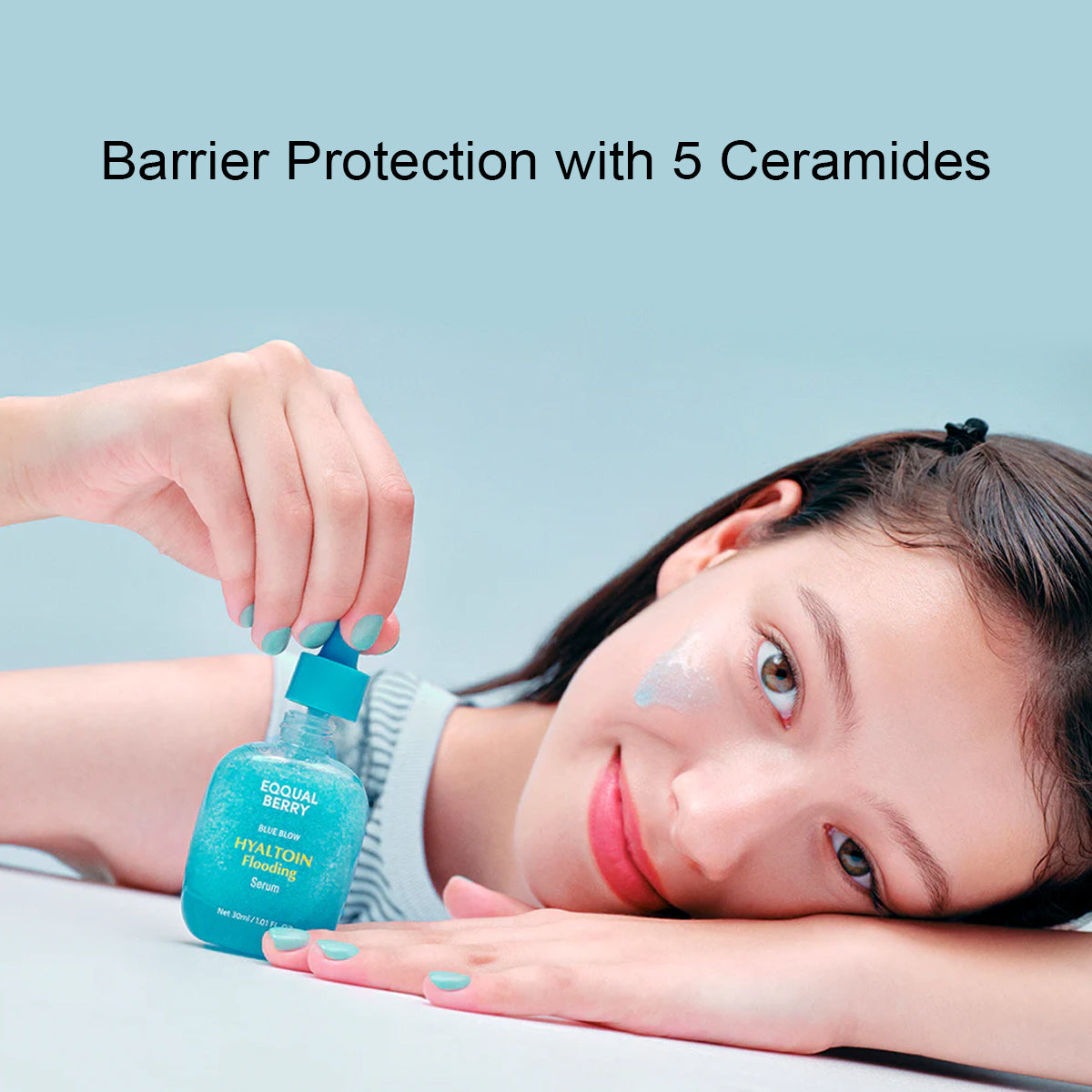 Woman applying a blue bottle labeled 'Ecoful Berry' to her face with a light blue background.